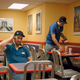 Employee Randy Leyner (left) sits while Ehrman clears a table.